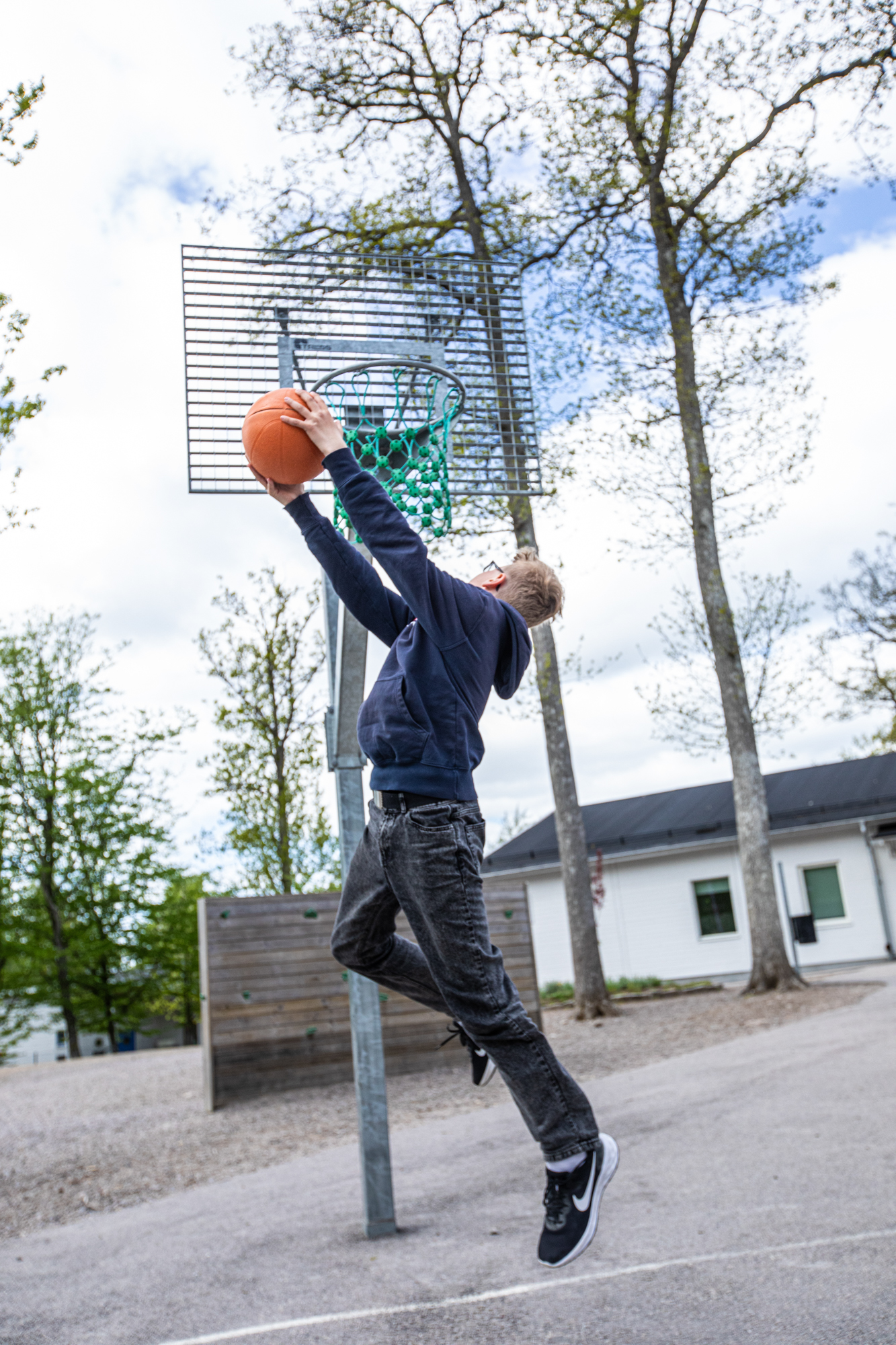 Mellanstadieelev spelar basket på skolgård